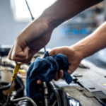 mani di un meccanico a lavoro nel cofano di un'auto