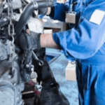 meccanico del quale non si vede il volto con tuta blu al lavoro