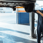 due meccanici controllano un'auto su un ponte